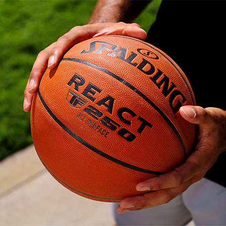 Male Model holding React TF 250 basketball.  